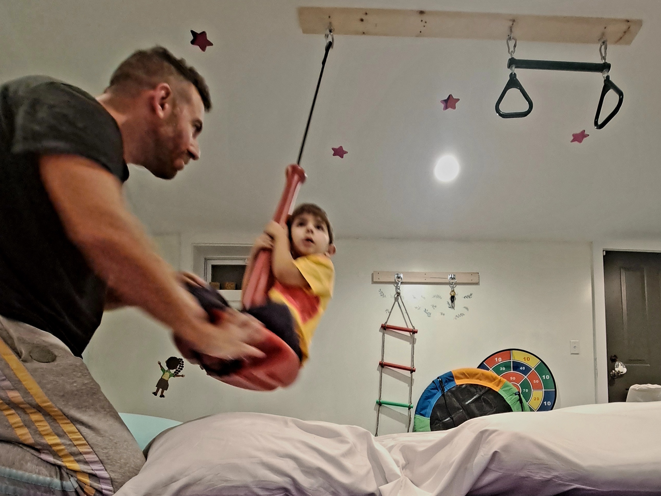 Adult therapist playing with young child in home gym